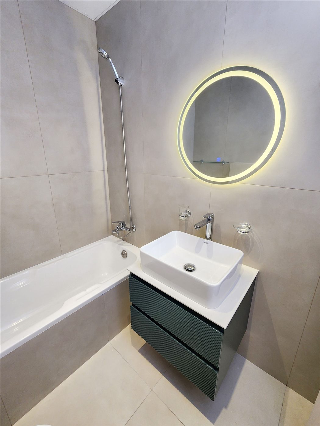 Master bathroom: bathtub, fluted vanity, backlit mirror