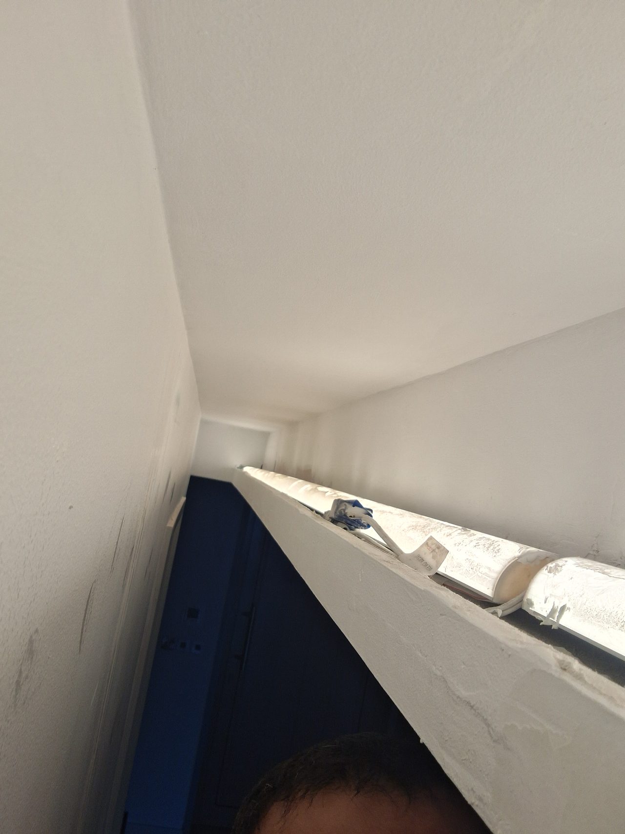 The process of carefully painting and preparing a narrow ceiling niche with integrated lighting