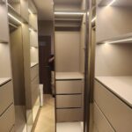 Built-in walk-in closet with illuminated shelves and mirrored facades