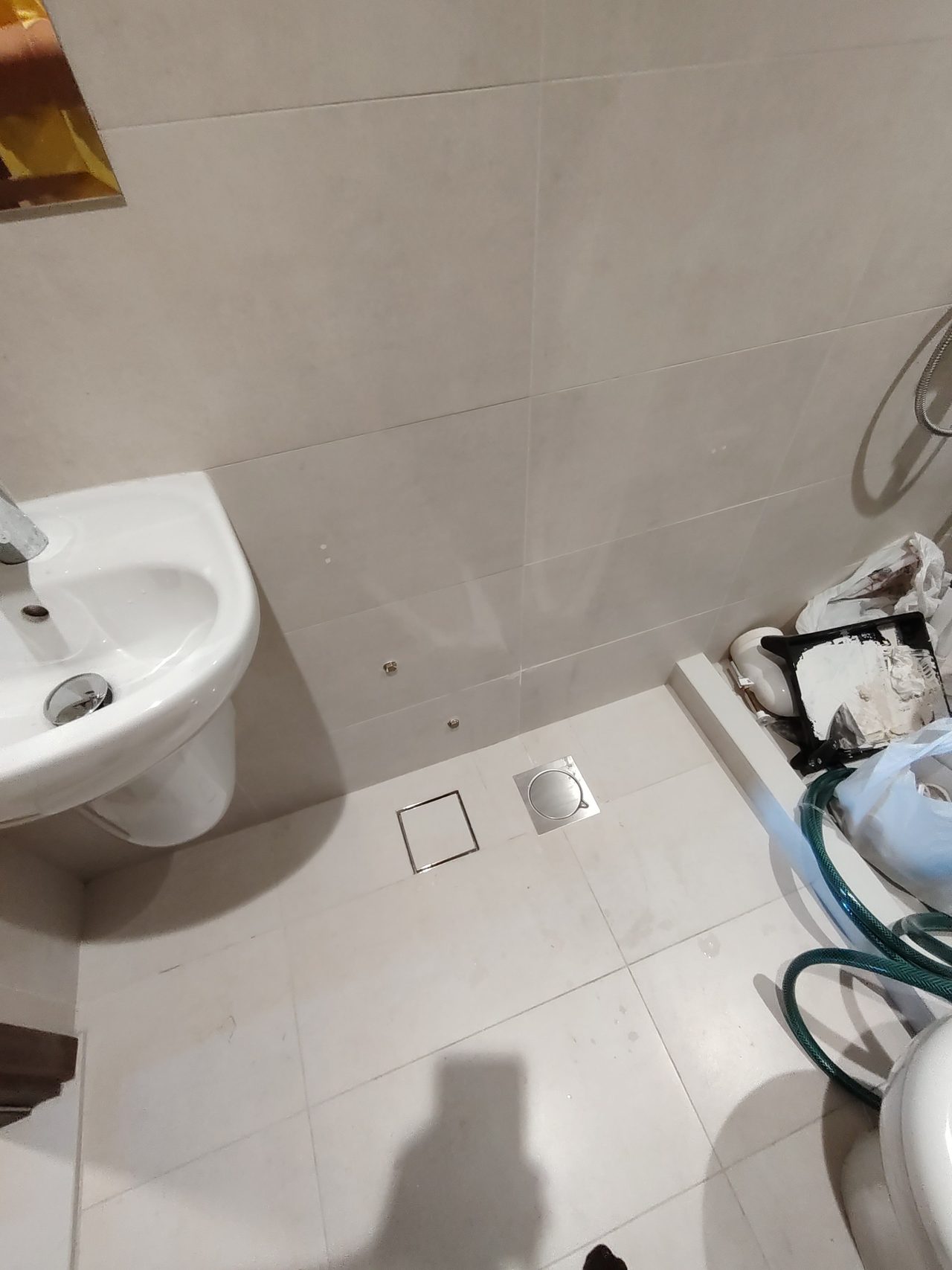 Top view of the installed sink and floor drains in the bathroom