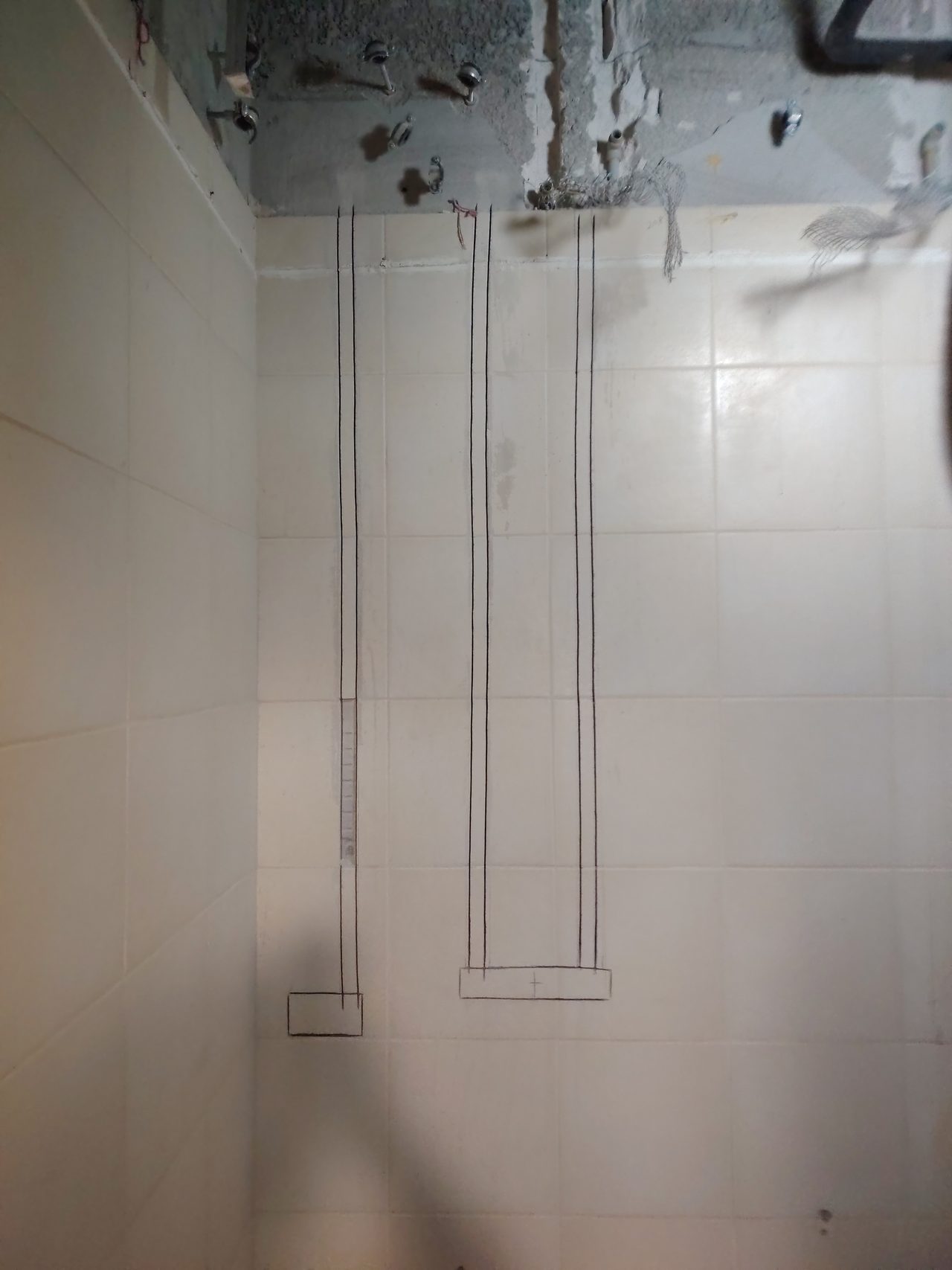 Markings on the tiled walls of the guest toilet for subsequent chasing for cable lines