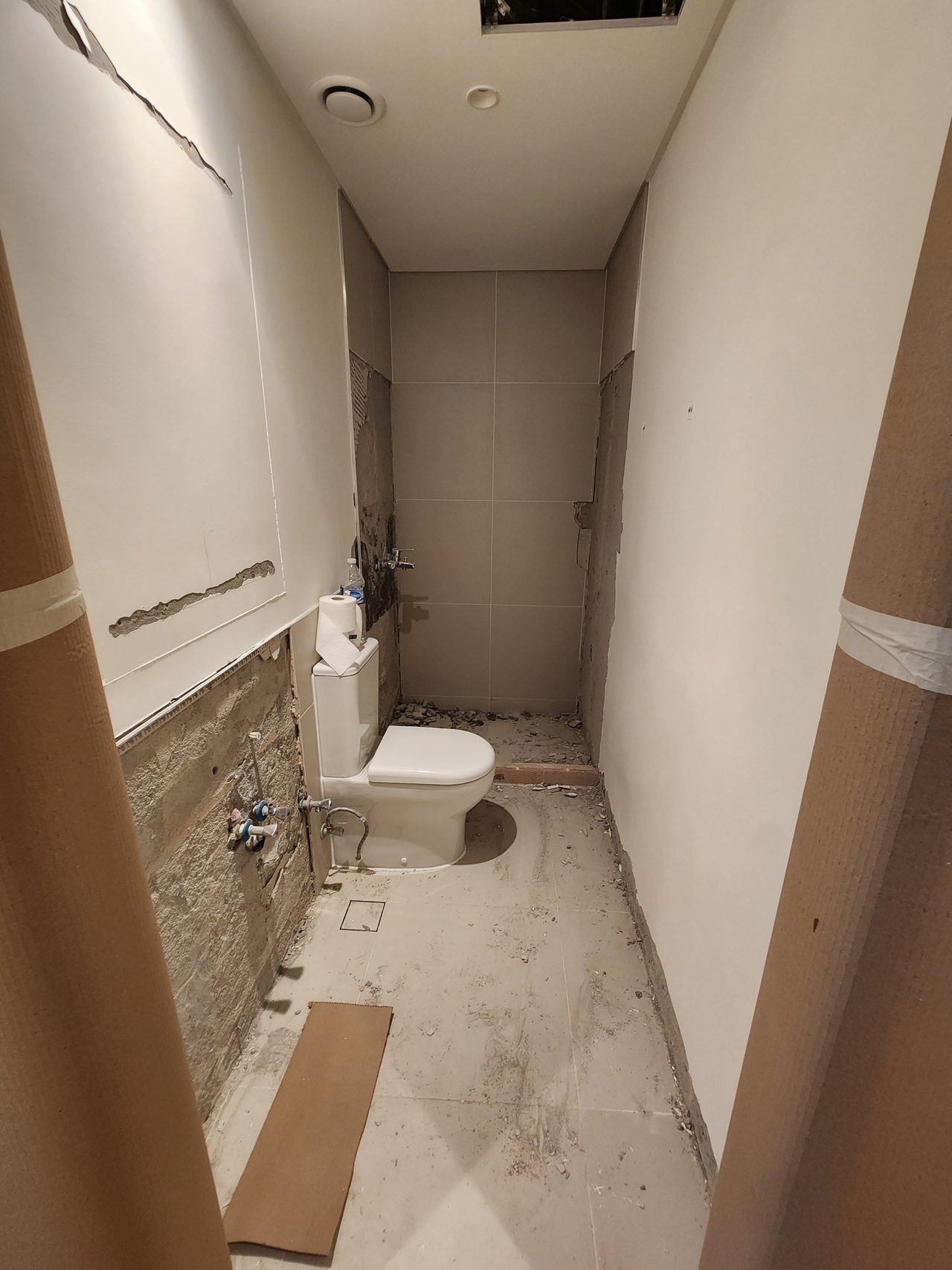 Demolition works in the shared bathroom. The doorway sides are protected with thick cardboard, minimizing the risk of damage to finished structures