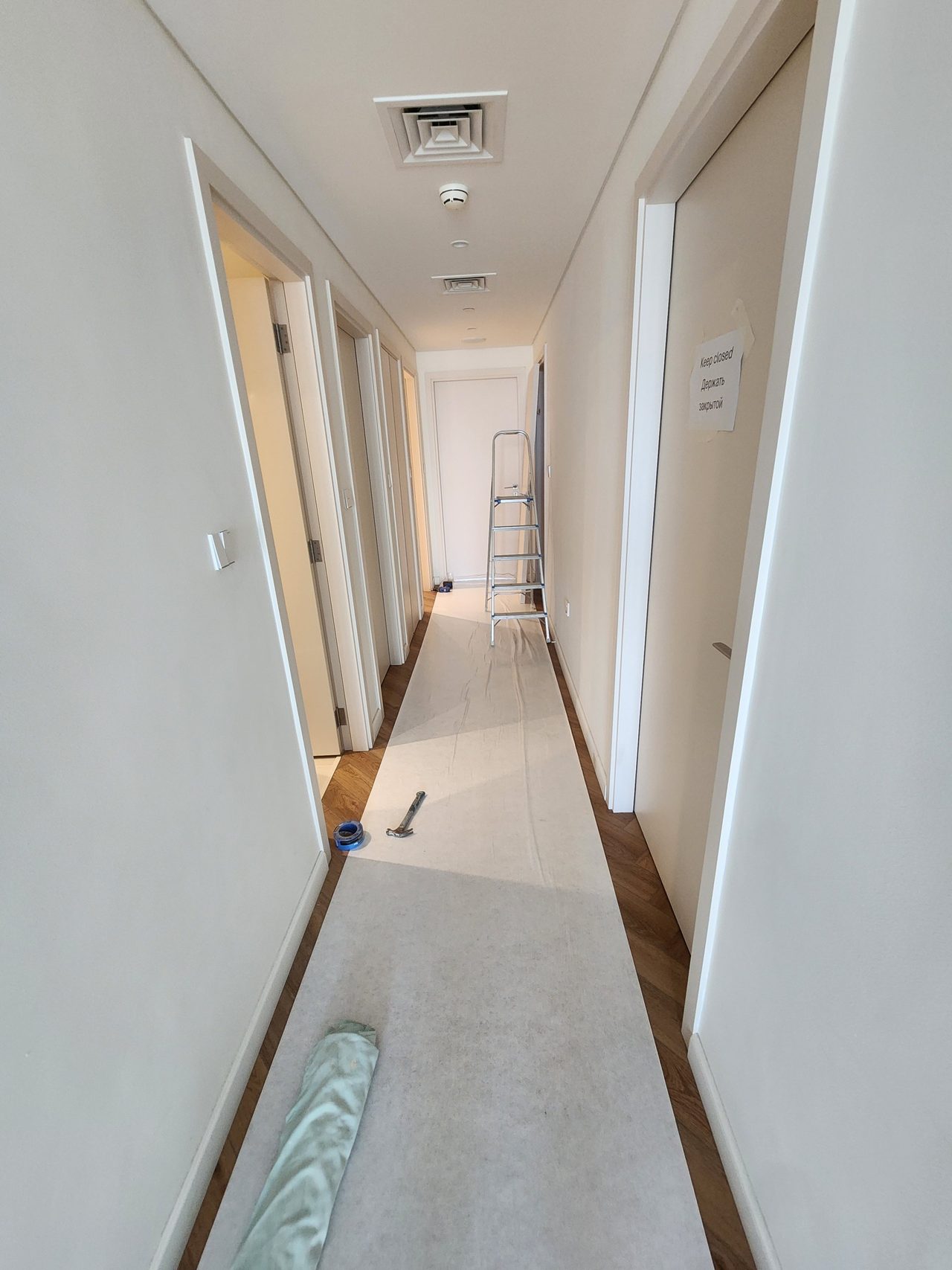 The finished corridor flooring is reliably protected with heavy-duty floor covering before installation work begins