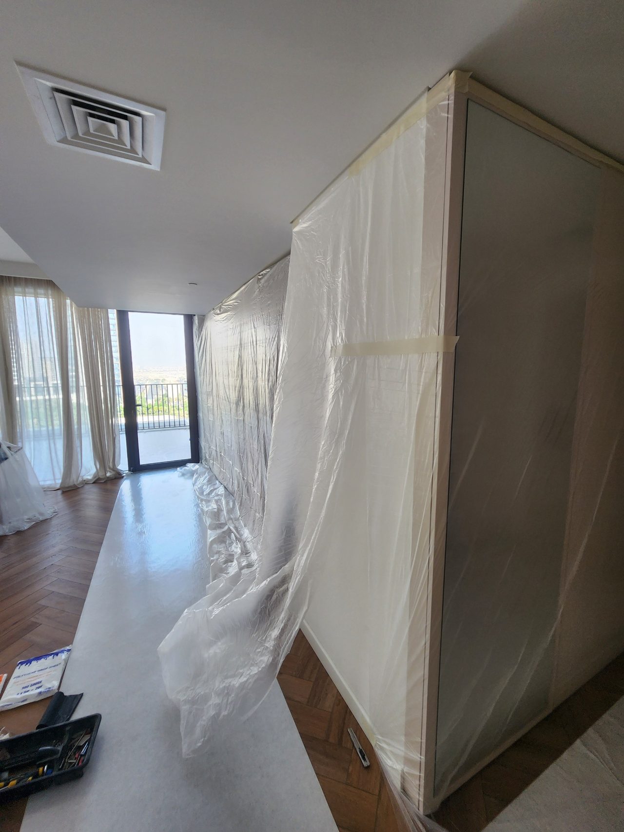 Thorough covering of built-in furniture and partitions with protective film before starting dusty work